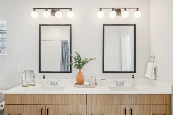 a bathroom with double vanity sinks a vanity and a mirror