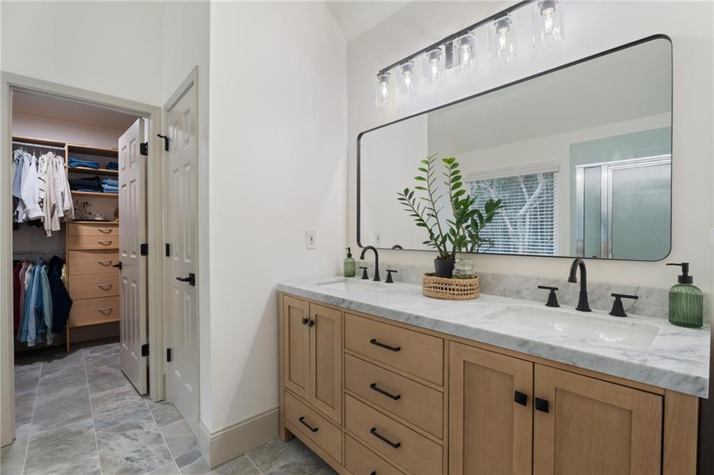 2625 Crosswynd Terrace Cumming, GA 30040 - Photo 11 of 20 a bathroom with a granite countertop sink a potted plant and a mirror