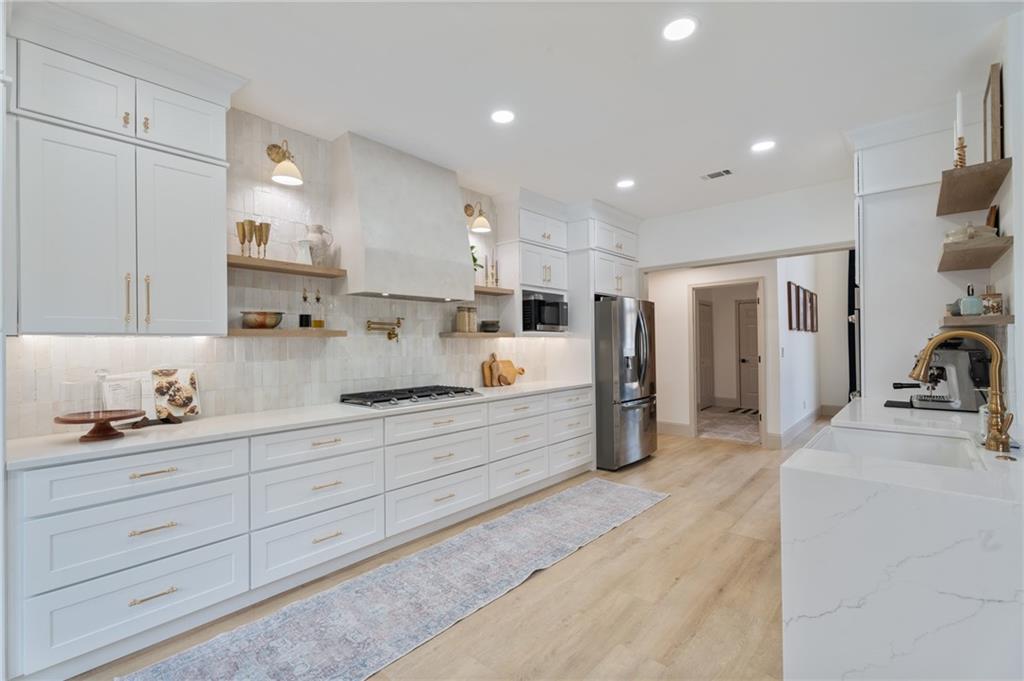 2625 Crosswynd Terrace Cumming, GA 30040 - Photo 7 of 20 a large kitchen with stainless steel appliances lots of counter space and wooden floor