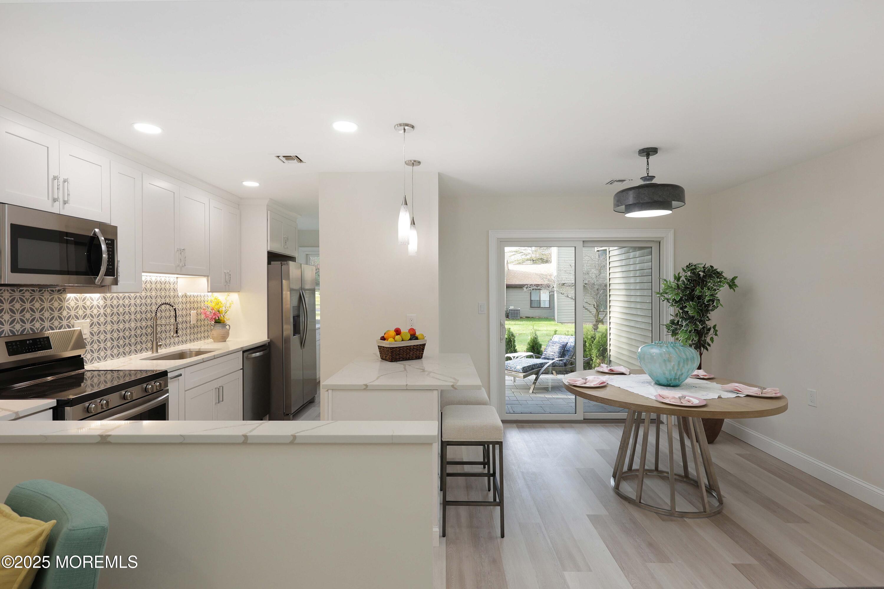 3 Auburn Court Red Bank, NJ 07701 - Photo 14 of 57 a kitchen with stainless steel appliances kitchen island granite countertop a refrigerator a stove a dining table and chairs with wooden floor