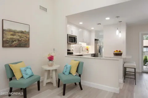 a kitchen with a dining table chairs and refrigerator