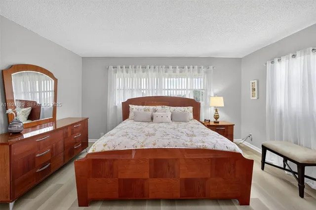 a bedroom with a large bed and wooden floor