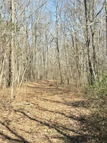 a kitchen with a refrigerator a stove a sink and a dining table with wooden floor