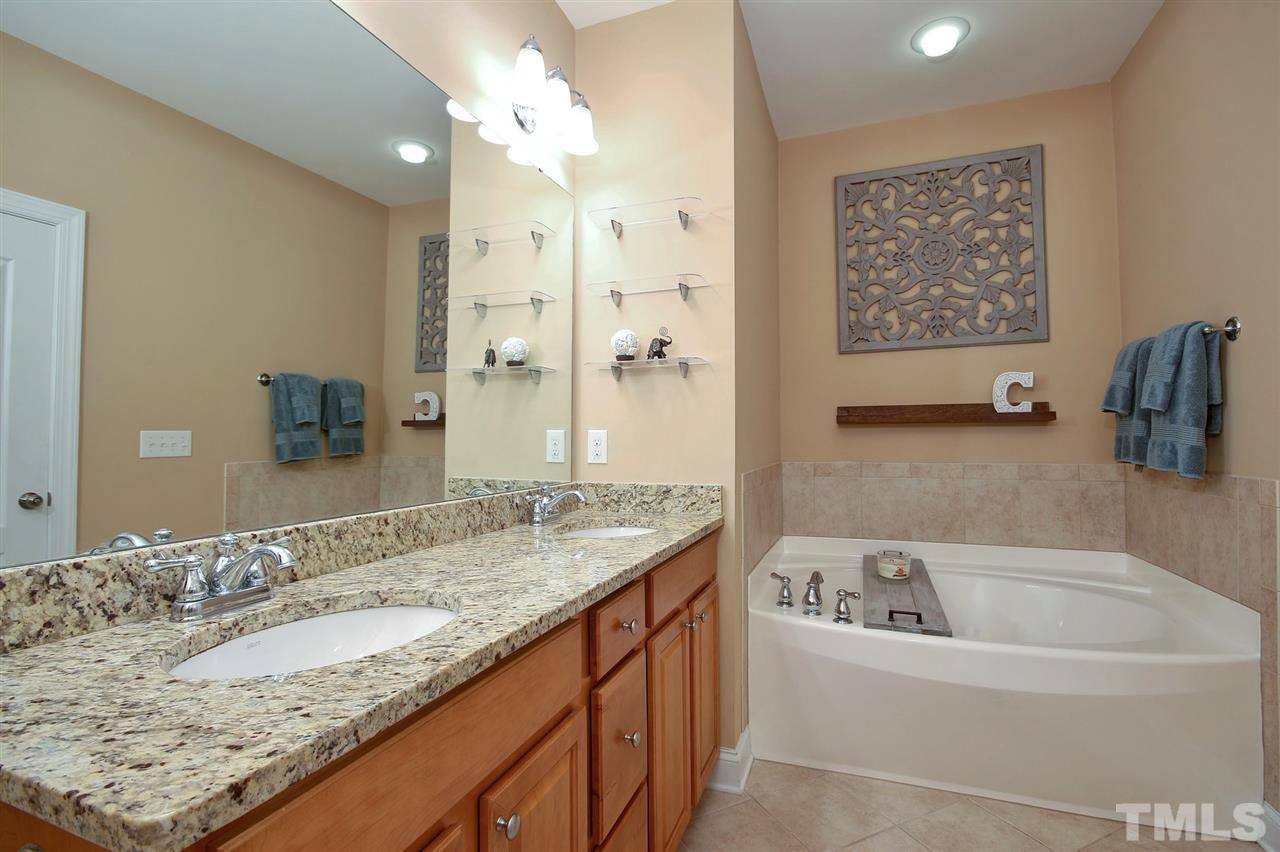 620 Democracy Street Raleigh, NC 27603 - Photo 14 of 24 Granite counter tops continue in your master bath. Vanity with storage and a garden tub with separate shower.