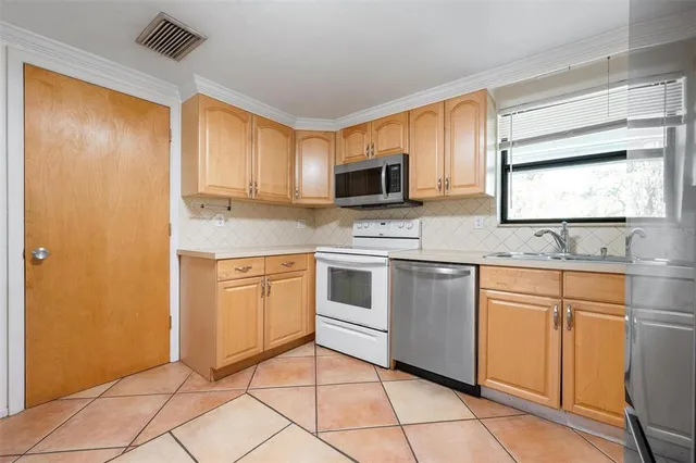 a kitchen with stainless steel appliances granite countertop a stove a sink and a microwave