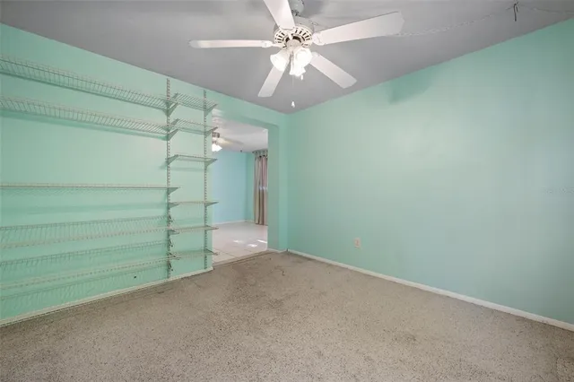 en empty room with a fan and window