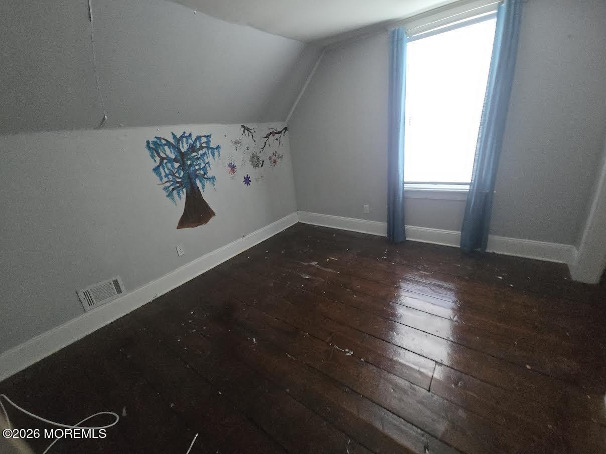 254 First Avenue Atlantic Highlands, NJ 07716 - Photo 15 of 18 an empty room with wooden floor and windows