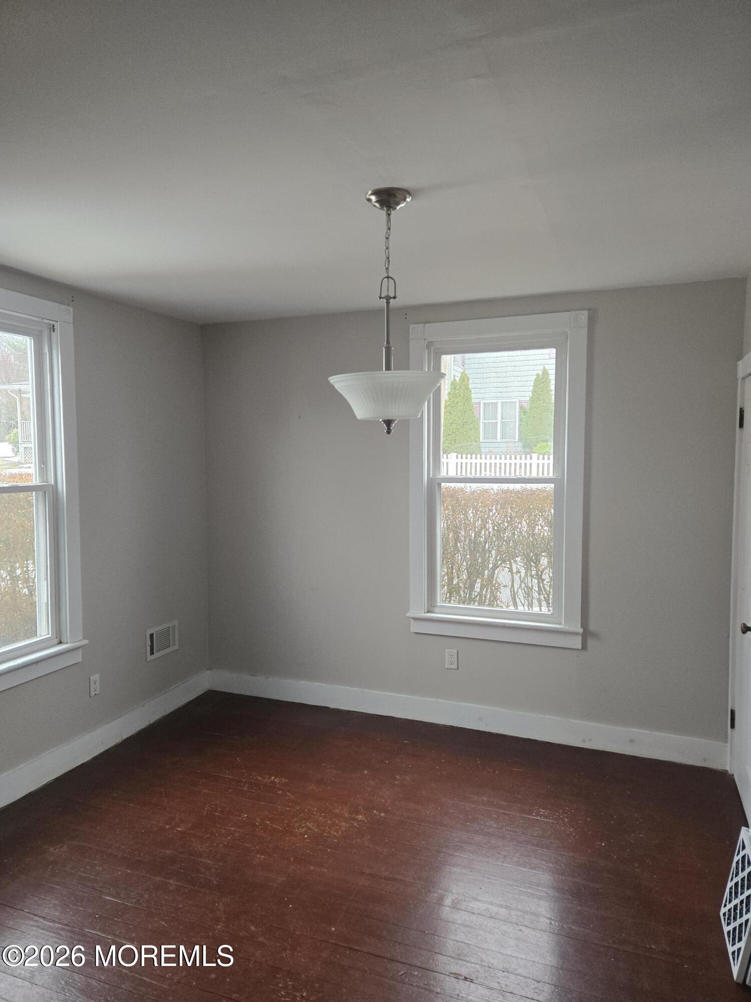 254 First Avenue Atlantic Highlands, NJ 07716 - Photo 6 of 18 an empty room with wooden floor and windows