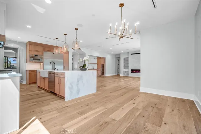 a view of an empty room with wooden floor and windows