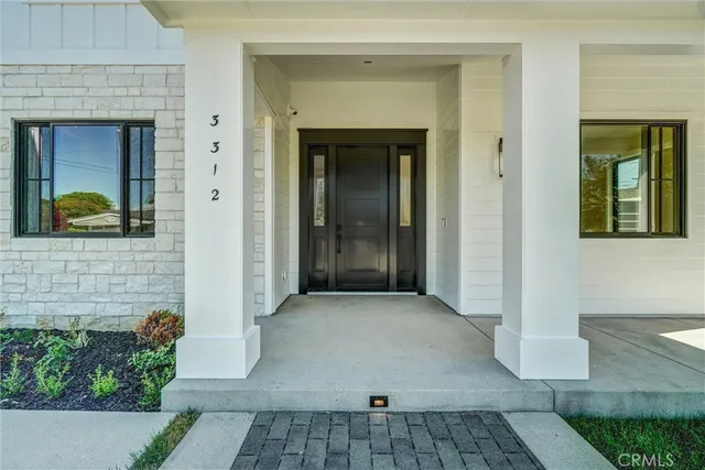 an empty room with wooden floor chandelier and a window