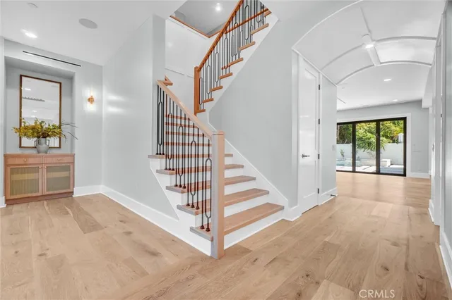 a kitchen with stainless steel appliances granite countertop a sink a stove a refrigerator and island with wooden floor