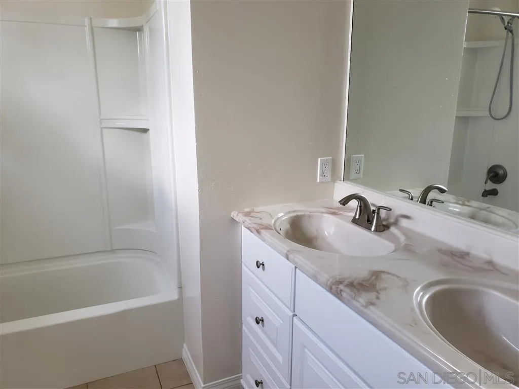 13425 Hilldale Road Valley Center, CA 92082 - Photo 12 of 13 a bathroom with a granite countertop sink a mirror and a bathtub