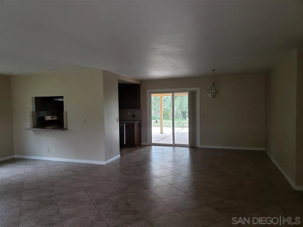 13425 Hilldale Road Valley Center, CA 92082 - Photo 6 of 13 a view of an empty room with a window and a kitchen