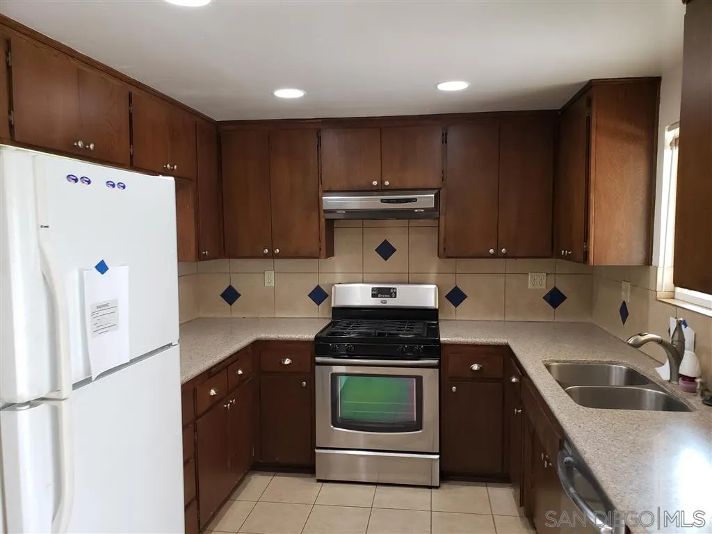 13425 Hilldale Road Valley Center, CA 92082 - Photo 7 of 13 a kitchen with a refrigerator a stove a sink and cabinets