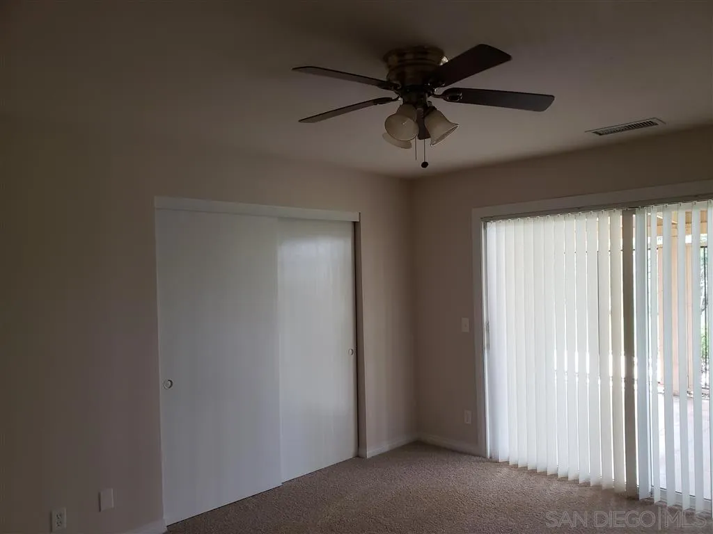 13425 Hilldale Road Valley Center, CA 92082 - Photo 9 of 13 an empty room with a ceiling fan and window