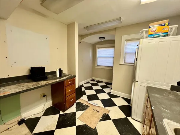 a kitchen with a checkered floor and white cabinets