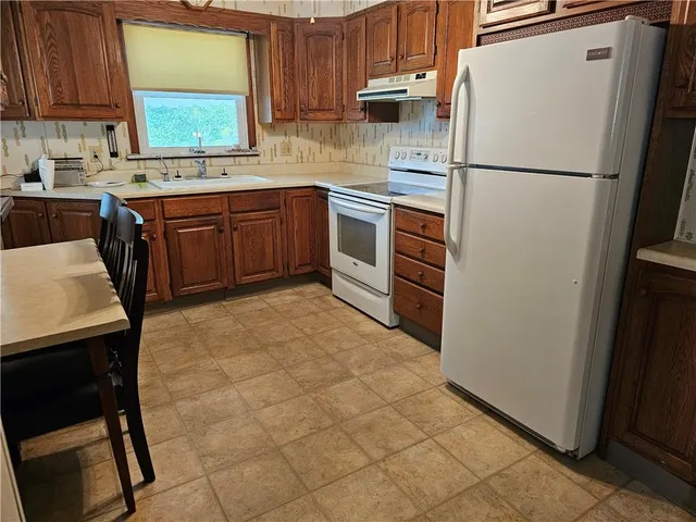 a kitchen with appliances a sink and cabinets