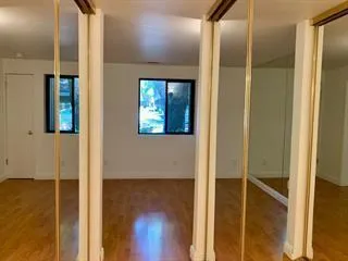 a view of a big room with wooden floor chandelier and windows