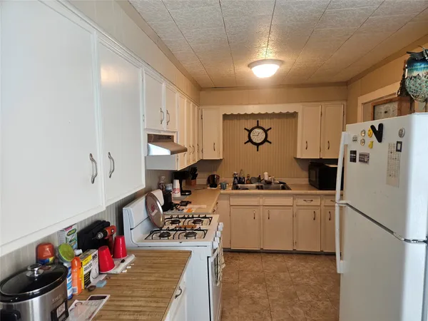 a kitchen with white cabinets and white appliances