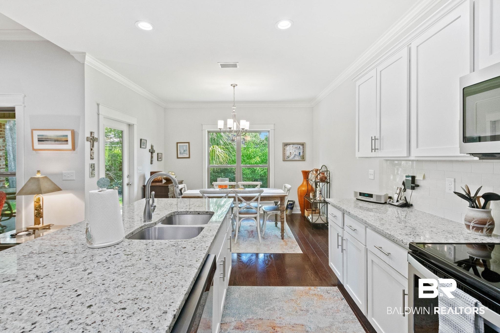 192 Mark Twain Loop Foley, AL 36535 - Photo 12 of 42 Kitchen featuring stainless steel appliances, dark hardwood / wood-style flooring, crown molding, sink, and backsplash
