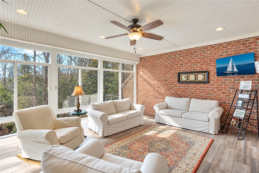 114 Augusta National Anderson, SC 29621 - Photo 17 of 44 An exposed brick wall and upgraded flooring anchor this sun-drenched four-season room.