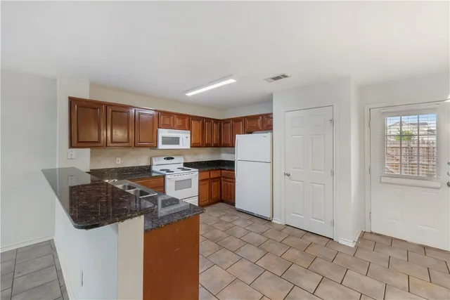 a kitchen with stainless steel appliances granite countertop a stove a sink and a refrigerator
