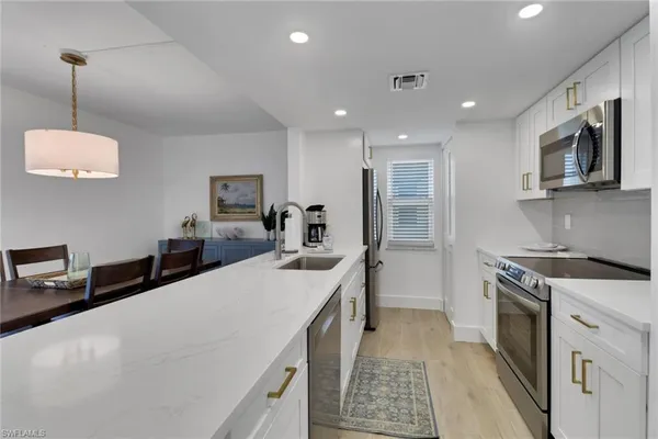 a open kitchen with stainless steel appliances granite countertop a sink stove and refrigerator