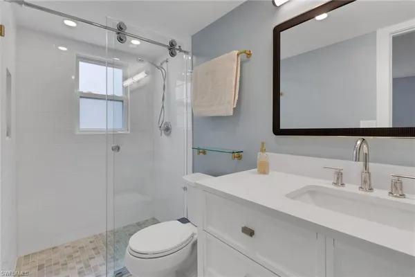 a bathroom with a sink a toilet and shower