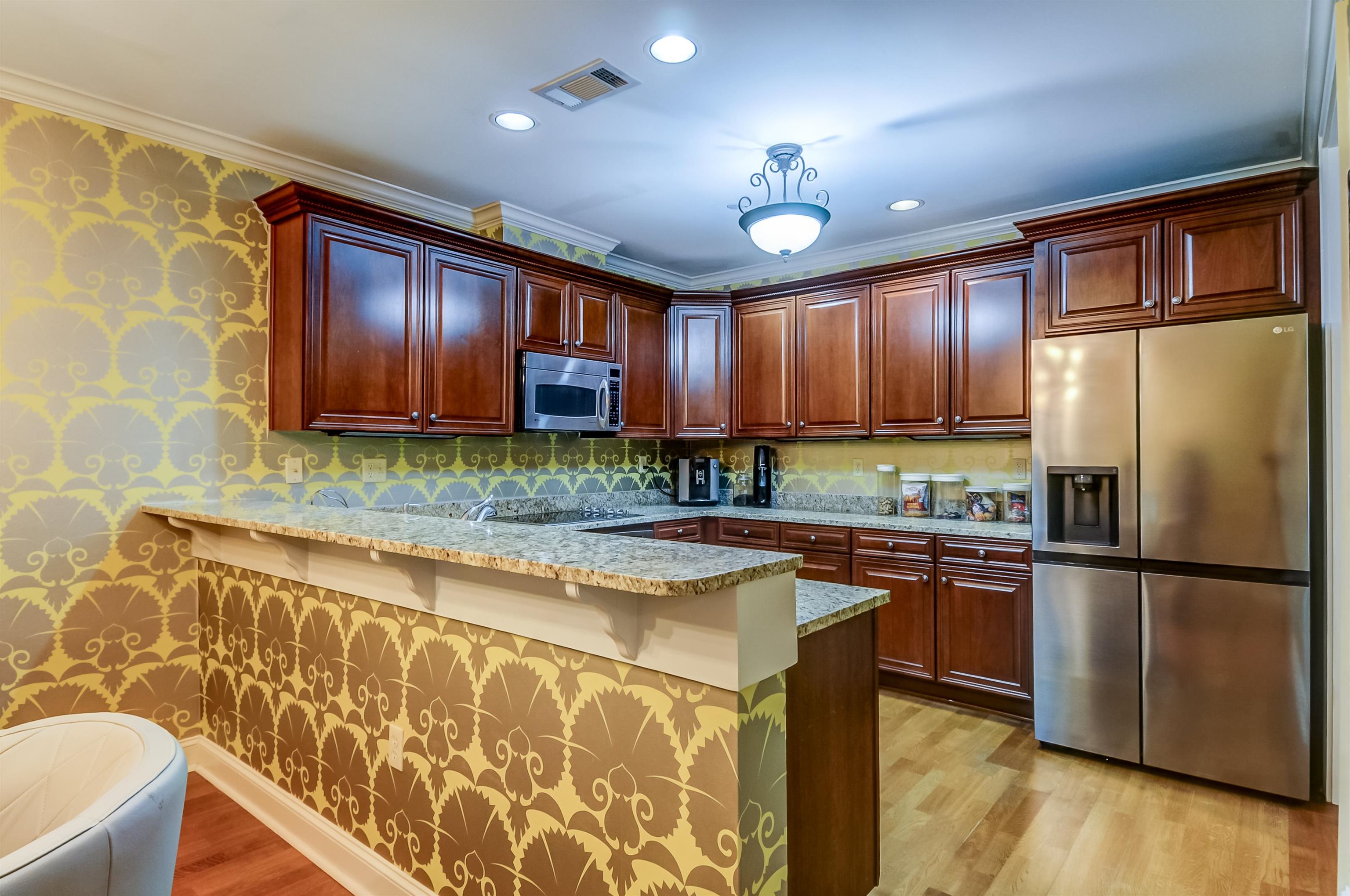 591 Lexington Road, Unit 303 Memphis, TN 38117 - Photo 15 of 34 a kitchen with stainless steel appliances granite countertop a refrigerator a stove top oven and a sink with wooden floor