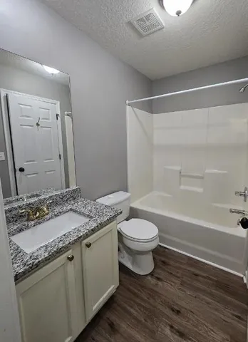 a bathroom with a granite countertop sink toilet a large mirror and shower