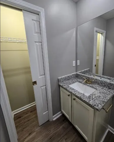 a bathroom with a granite countertop sink and a mirror