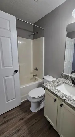 a bathroom with a granite countertop sink toilet and shower