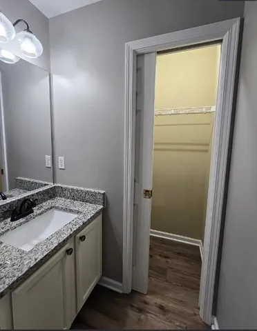 a bathroom with a granite countertop sink and a mirror