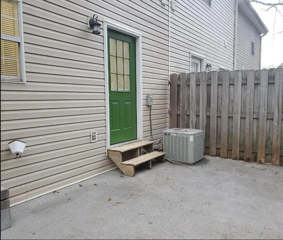 a view of a patio with a table and chairs and a barbeque