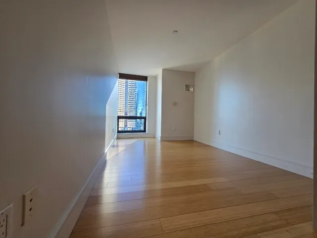 a view of an empty room and wooden floor