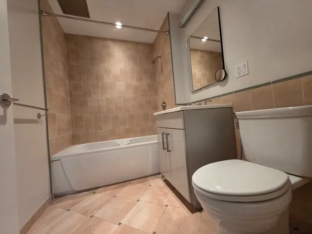 a white toilet sitting next to a bath tub shower