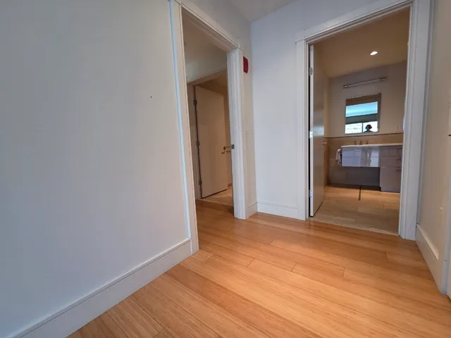 a view of a room with wooden floor and a bathroom