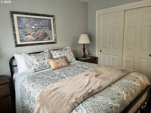 a bedroom with a bed and a painting on the wall