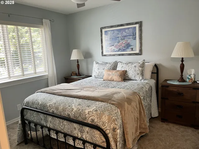 a bedroom with a bed and a lamp on dresser