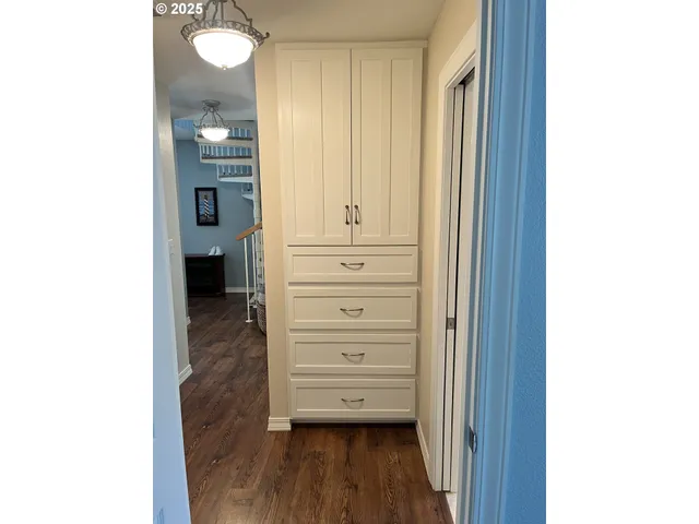 a view of a hallway with closet and wooden floor