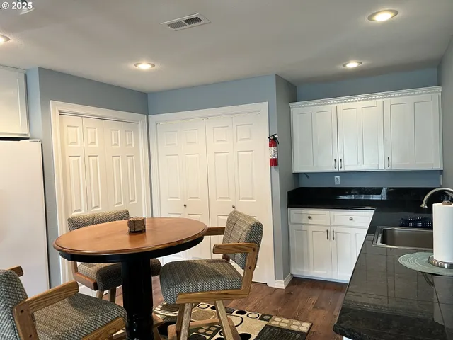 a kitchen with a sink a table and chairs in it