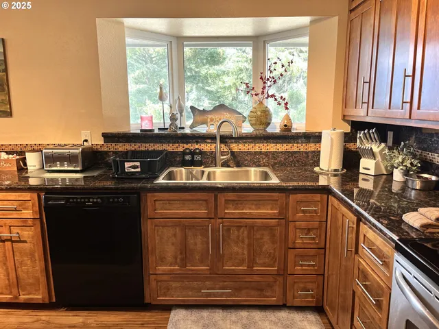 a kitchen with stainless steel appliances granite countertop a stove a sink and a microwave