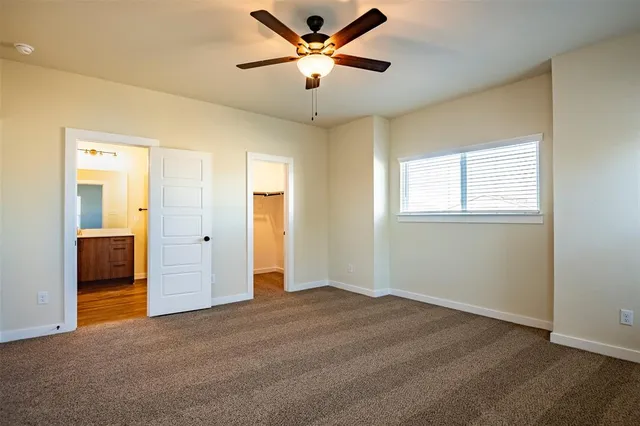 a view of a livingroom with a chandelier fan and a window