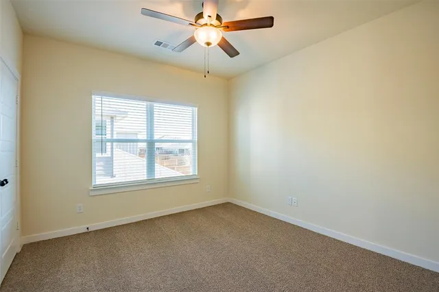 an empty room with a window and a fan