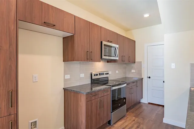 a kitchen with stainless steel appliances granite countertop white cabinets stove a sink and dishwasher