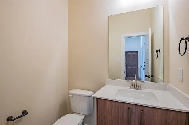 a bathroom with a sink vanity mirror and toilet