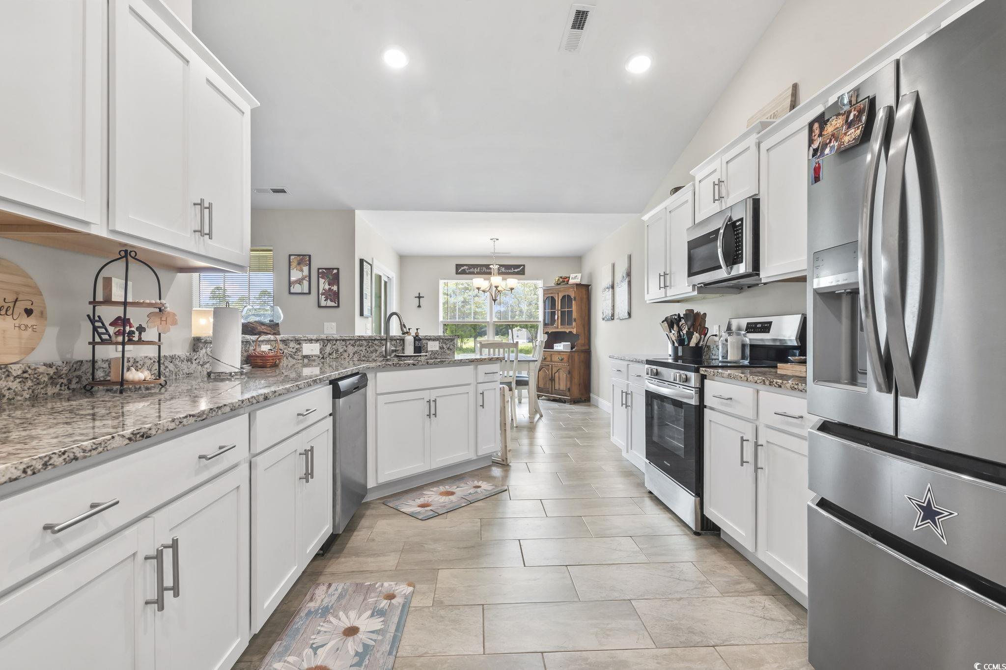 1170 Daisy Road Loris, SC 29569 - Photo 13 of 35 Kitchen with stainless steel appliances, a peninsula, a chandelier, white cabinets, and recessed lighting
