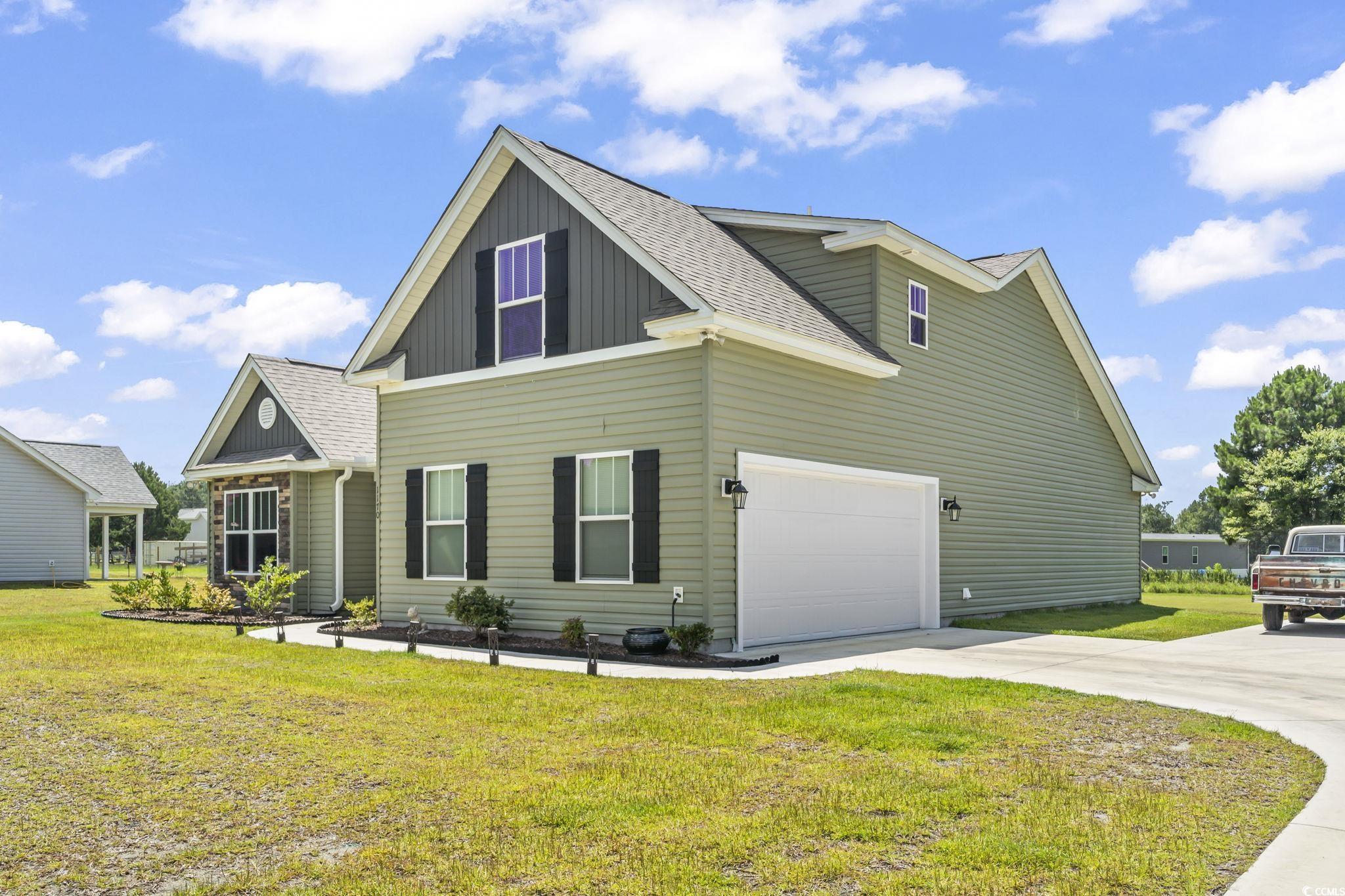 1170 Daisy Road Loris, SC 29569 - Photo 2 of 35 View of property exterior featuring driveway, roof with shingles, a yard, and board and batten siding