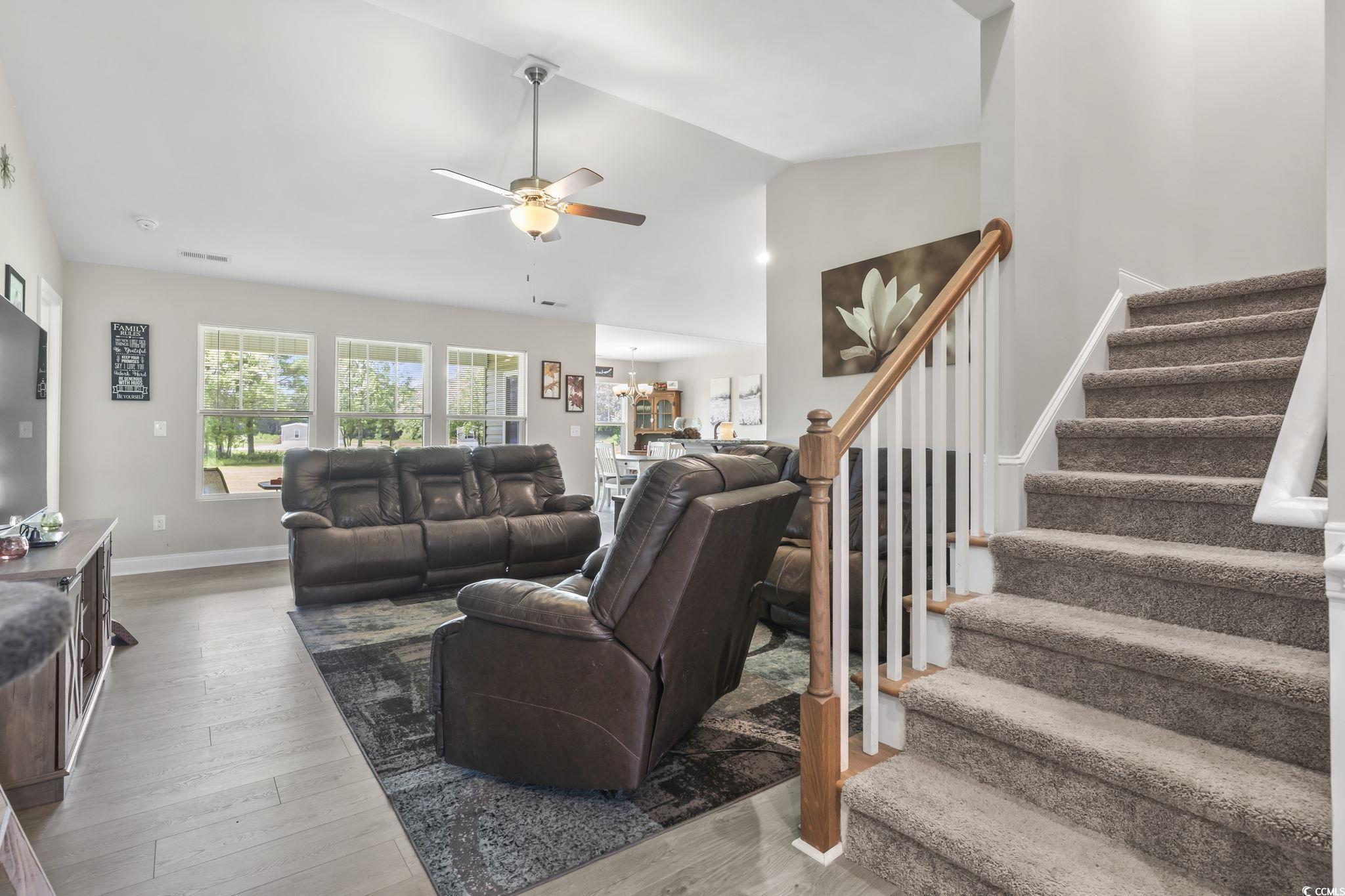 1170 Daisy Road Loris, SC 29569 - Photo 5 of 35 Living room with stairway, ceiling fan, wood finished floors, lofted ceiling, and a chandelier