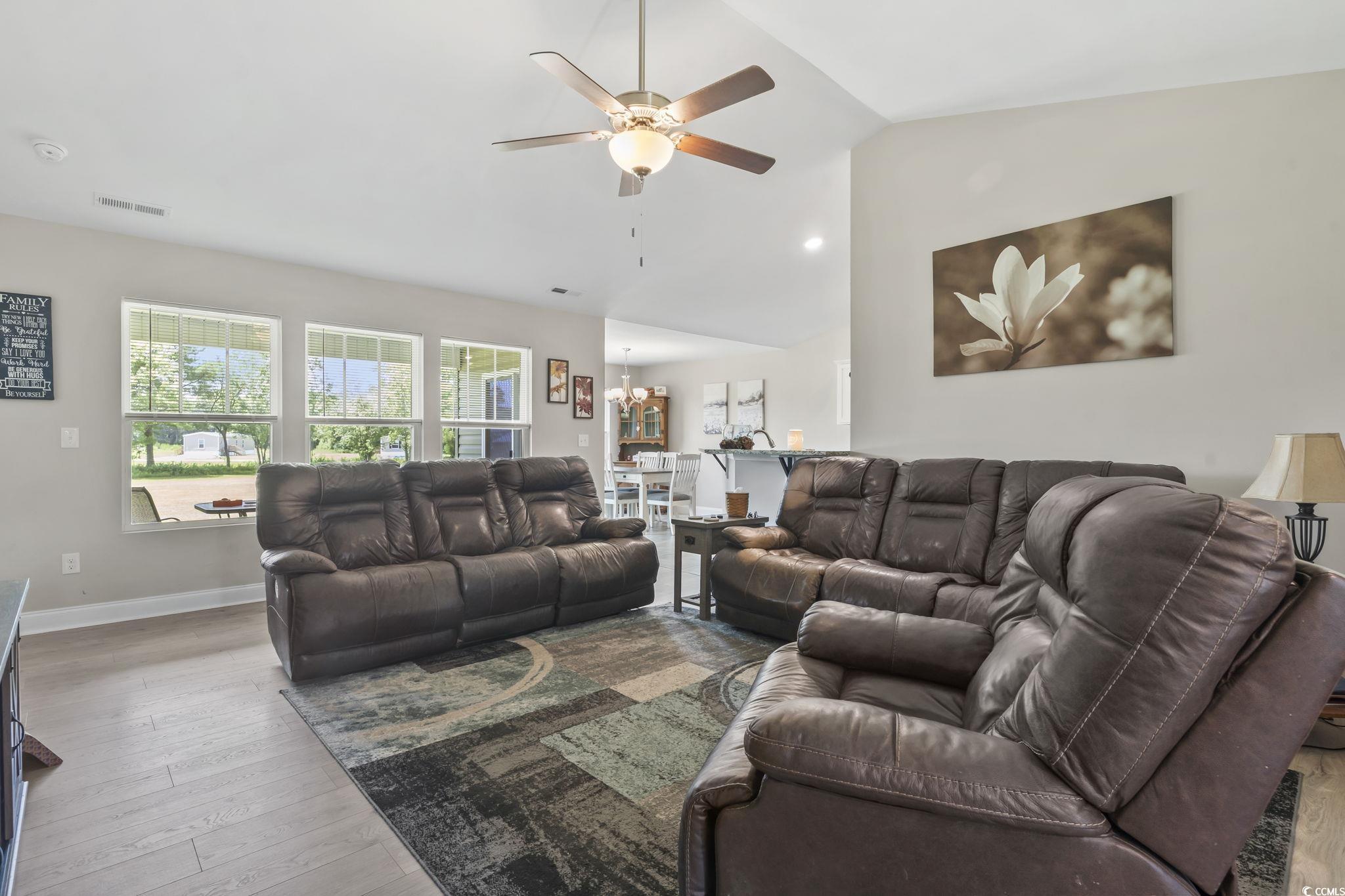 1170 Daisy Road Loris, SC 29569 - Photo 6 of 35 Living area featuring vaulted ceiling, a ceiling fan, wood finished floors, and a chandelier